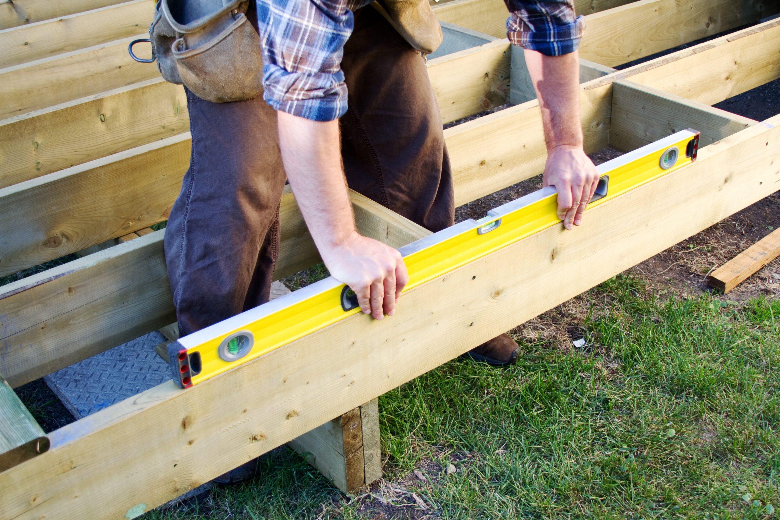 Contractor leveling a deck frame at JR Decks and Pergolas